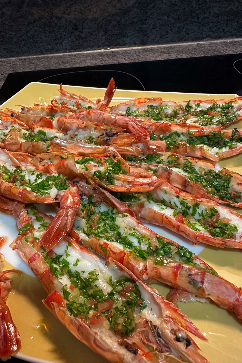 Grilled prawns garnished with fresh herbs on a plate